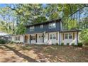 Two-story home with white brick and dark gray siding, featuring a covered porch at 3429 Mount Gilead Sw Rd, Atlanta, GA 30331