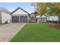 Two-car garage and front yard of charming house with brick and shingle exterior at 100 Jericho Dr, Covington, GA 30016