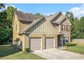 Two-story house with brick and siding, two-car garage, and landscaped lawn at 1185 Paramount Dr, Mcdonough, GA 30253