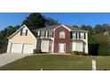 Two-story brick and siding house with a two-car garage and manicured lawn at 2608 Downing Park Se Dr, Conyers, GA 30094