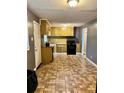 Kitchen with yellow cabinets, brick backsplash, and tiled floor at 207 Howell Dr, Atlanta, GA 30331