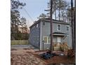 Two-story gray house with wooden steps and porch, and a wooded backyard at 7190 Buck Creek Dr, Fairburn, GA 30213