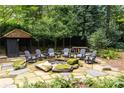 Landscaped backyard with a fire pit, seating area, and stone pathways at 4155 Flintlock Road Nw, Atlanta, GA 30327