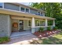 Charming front porch with hanging plants and landscaping at 174 Rivertown Rd, Fairburn, GA 30213