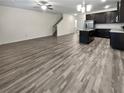 Open living room and kitchen with gray wood-look flooring, creating a spacious and modern feel at 5120 Lower Elm St, Atlanta, GA 30349