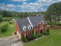 Aerial view of a two-story house with a pond and lush green landscape at 2505 Westchester Way, Conyers, GA 30013