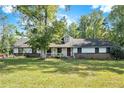 Ranch home with a large front yard and mature trees at 1736 Pleasant Grove Rd, Temple, GA 30179