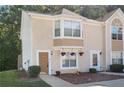 Tan two-story townhouse with a brown door and landscaping at 3127 Fields Dr, Lithonia, GA 30038