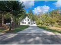 White farmhouse with concrete driveway and a spacious lawn at 3563 Denby Dr, Snellville, GA 30039