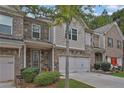 Brick front townhouse with 2-car garage and landscaped yard at 5820 Keystone Pt, Lithonia, GA 30058