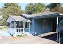 Light blue home with white trim, covered porch and carport at 6251 Pisgah Sw Rd, Mableton, GA 30126