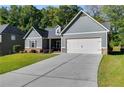 Gray house with stone accents, a two-car garage, and a concrete driveway at 1108 Red Bud Cir, Villa Rica, GA 30180