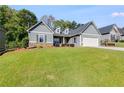 Gray house with stone accents, a two-car garage, and a large front yard at 1108 Red Bud Cir, Villa Rica, GA 30180