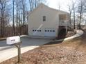 Rear view of a house featuring a two-car garage and deck at 434 Spring Leaf Dr, Dallas, GA 30157
