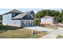 Two-story home with gray siding, two-car garage, and landscaped lawn at 1877 Holmsey Cir, Conyers, GA 30094