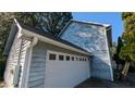 Attached garage with white door and gray siding at 5152 Edinburgh Nw Ct, Lilburn, GA 30047