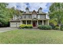 Two-story house with stone accents, a red door, and a landscaped lawn at 1720 Mountainside Dr, Cumming, GA 30040