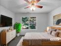 Virtually staged main bedroom with a wooden bed frame and large window at 3217 Fairington Dr, Lithonia, GA 30038