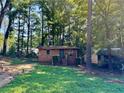 Brick cottage nestled in a wooded area with a grassy yard at 435 Warren Ave, Scottdale, GA 30079