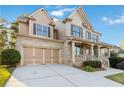 Two-story house with brick and siding, three-car garage, and covered porch at 1712 Country Wood Dr, Hoschton, GA 30548