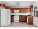 Kitchen with wood cabinets, white appliances, and tile flooring at 3589 Orchard Cir, Decatur, GA 30032