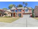 Two-story brick home with landscaping and a driveway at 3191 Lake Mcginnis Dr, Suwanee, GA 30024