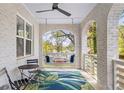 Inviting front porch with swing, brick columns, and a tropical-print rug at 1696 Emerald Sw Ave, Atlanta, GA 30310