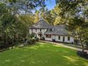 Large home nestled in a wooded lot with a brick walkway leading to the entrance at 5735 Winterthur Ln, Atlanta, GA 30328