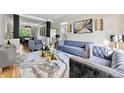 Spacious living room with plush blue velvet sofas and a marble-top coffee table at 4478 Thurgood Estates Dr, Ellenwood, GA 30294