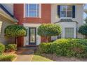 House entrance with brick, bushes, and a black door at 2404 Lake Cove Ct, Lithonia, GA 30058