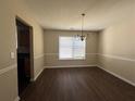 Formal dining room with chandelier and hardwood floors at 325 Welsh Ct, Fairburn, GA 30213