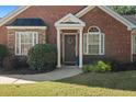 Brick home with stone accents, a welcoming porch, and well-manicured landscaping at 204 Somerton Pl, Cumming, GA 30040
