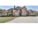 Large brick home with stone accents, a circular driveway, and manicured lawn at 187 Fontaine Sw Rd, Mableton, GA 30126