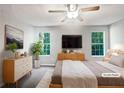 Virtually staged main bedroom with large windows and dresser at 2988 Woodrow Mnr, Lithonia, GA 30038