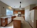 Kitchen with island, wood cabinets, and appliances at 925 Bendleton Dr, Woodstock, GA 30188