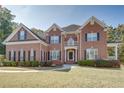 Brick two-story house with a large front yard and manicured landscaping at 2312 Mallory Cir, Conyers, GA 30094