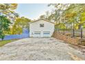 Two-car garage with concrete driveway and retaining wall at 2933 Indian Shoals Rd, Dacula, GA 30019