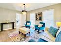 Bright living room with teal armchairs and a light beige sofa, featuring a large rug at 430 Thornbush Trce, Lawrenceville, GA 30046