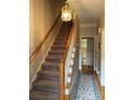 Elegant staircase with wooden railing and a chandelier at 220 Spalding Lake Pl, Atlanta, GA 30350