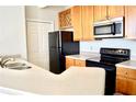 Modern kitchen with light wood cabinets and black appliances at 32 Peachtree Nw St # 1006, Atlanta, GA 30303