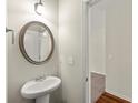 Small bathroom with pedestal sink and round mirror at 13 Canyon Se Trl, Cartersville, GA 30121