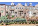 Three-story brick townhouse with gray door and landscaping at 1813 Hislop Ln, Atlanta, GA 30345