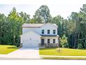 Two-story house with white siding, stone accents, and a two-car garage at 134 Henley St, Canton, GA 30114