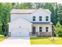 Two-story house with white siding, stone accents, and a two-car garage at 134 Henley St, Canton, GA 30114