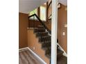 Indoor staircase with carpeted steps and metal railing at 8596 Creekwood Way, Jonesboro, GA 30238