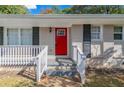 Front porch with red door and white railing at 929 Pine Roc Dr, Stone Mountain, GA 30083