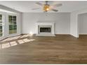 Living room featuring hardwood floors, fireplace, and large windows at 120 Birch Creek Cir, Mcdonough, GA 30253