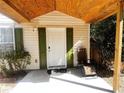 Covered entryway with green shutters, white door and a relaxing chair at 7094 Merrywood Ct, Fairburn, GA 30213