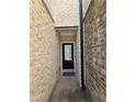 Private entryway with brick walls and a black front door leading into the home at 1702 Villageside Ct, Lawrenceville, GA 30043