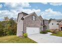 Attached garage with white door and landscaping at 4203 Shandi Cv, Hoschton, GA 30548